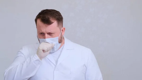 Doctor coughs in a protective mask infected with a virus or coronavirus. — Stock Photo, Image