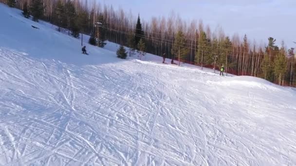 Top view of a snowboarder sliding down from the top of a mountain on a winter sunny day. The concept of snowboarding. — Stock Video
