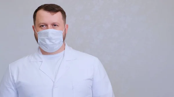 Koruyucu maskeli ve beyaz gömlekli bir adam kameraya bakıyor, yakından. Hijyen konsepti. Mikrop ve bakterilerin yayılmasını önlemek ve taç virüsünün bulaşmasını önlemek. Boşluğu kopyala — Stok fotoğraf