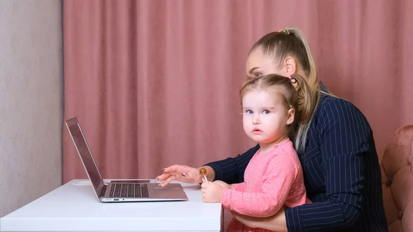 Mamma e figlio a casa a fare lezione guardando il portatile. Infanzia, insegnante. bambino con computer portatile sul tavolo. Discutere di informazioni . — Foto Stock