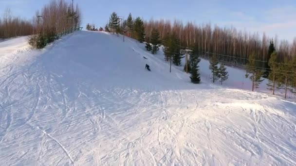 Сноубордист спускается с вершины горы в солнечный зимний день. Районный вид. Концепция сноуборда . — стоковое видео