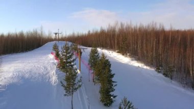 Üst düzey snowboardcular ve kayakçılar güneşli bir kış gününde özel bir asansörle dağ yamacına tırmanırlar. Kayak ve snowboard konsepti.