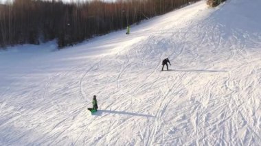 Kayakçılar ve snowboardcular karlı kış dağlarındaki bir kayak merkezinde kayıyorlar. Gerçek manzara. Kayak ve snowboard konsepti. 