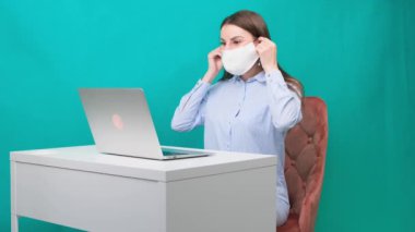 Kadın, iş yerinde ya da evde çalışırken koruyucu bir maske takıyor. Salgın sırasında. Karantina ve kendini izole etme süresince çalışma kavramı.