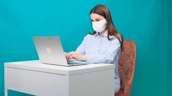 Frau, die zu Hause mit medizinischer Maske im Gesicht arbeitet. Coronavirus Quarantäne Remote Home Arbeitskonzept. — Stockfoto