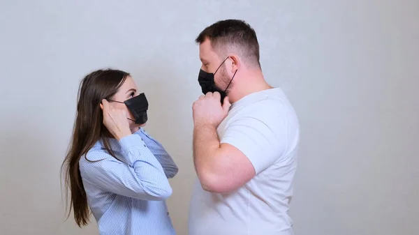 Женщины и мужчины смотрят друг на друга в защитных масках и обнимаются. Понятие гигиены. предотвратить распространение микробов и бактерий и избежать заражения вирусом короны — стоковое фото