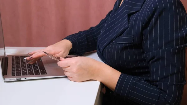 Kvinnliga händer gör ett köp på Internet med hjälp av en bärbar dator, betalning med kort, närbild. — Stockfoto