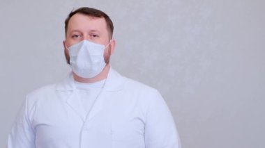 Doktor koruyucu bir maskeyle öksürüyor. Virüs veya koronavirüs bulaşmış..