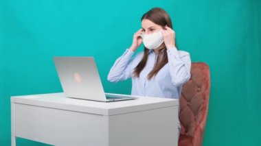 Kadın, iş yerinde ya da evde çalışırken koruyucu bir maske takıyor. Salgın sırasında. Karantina ve kendini izole etme süresince çalışma kavramı.