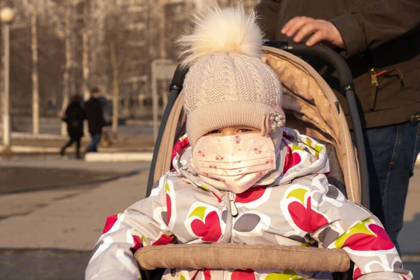 Gyerek egy babakocsiban apával az úton egy orvosi maszkban. Sűrű szmog az utcákon. Influenza járvány. — Stock Fotó