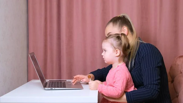 Working mom works from home office. Happy mother and daughter smiling. Successful woman and cute child using laptop. Freelancer workplace. Female business. It is not easy but she is up to the task