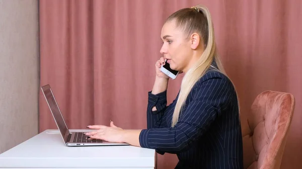 Ділова жінка працює в ноутбуці і розмовляє по телефону, віддалена робота. Завжди будьте готові, коли прийде бізнес . — стокове фото