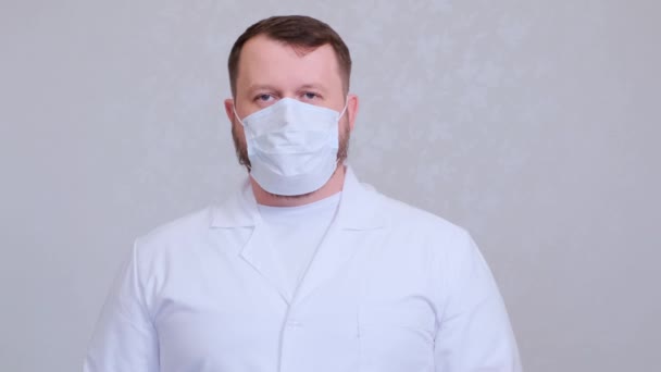 Een man met een baard in een zak op zijn hoofd. Angst voor infectie. Coronavirus COVID-19 Pandemie, zelfisolatie thuis en quarantaine. — Stockvideo