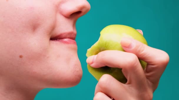 Υγιεινή διατροφή και υγιή δόντια ή διατροφή, νεαρή γυναίκα δαγκώνει ένα φρέσκο μήλο σε μια πράσινη οθόνη close-up — Αρχείο Βίντεο