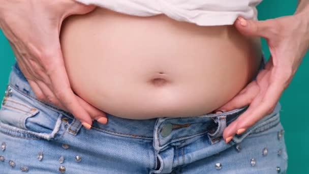 Толстая женщина, тучная женщина рука держит избыточный жир живота изолированы на зеленом фоне, избыточный жировой живот женщины, женщина диета образ жизни концепции, чтобы уменьшить живот и сформировать здоровую мышцу желудка — стоковое видео