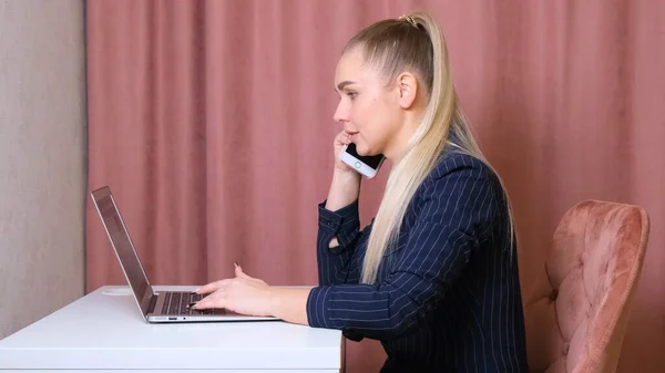 Ділова жінка працює в ноутбуці і розмовляє по телефону, віддалена робота. Завжди будьте готові, коли прийде бізнес . — стокове фото