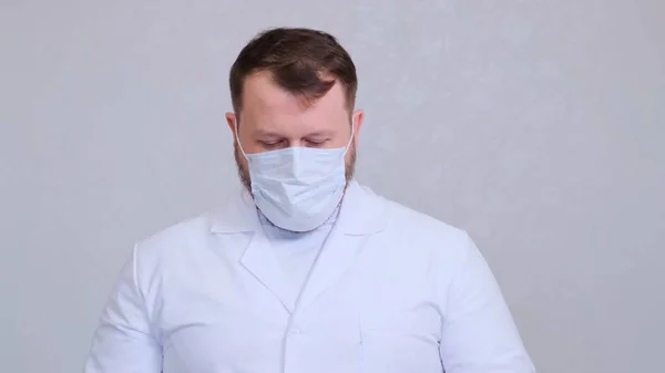Man met een beschermend masker en een wit overhemd hoofd gebogen. Hygiëne concept. de verspreiding van kiemen en bacteriën te voorkomen en besmetting met het kroonvirus te voorkomen. kopieerruimte — Stockfoto