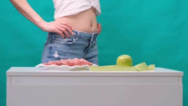 健康的なライフスタイル、食べ物やスポーツの概念。女性の手は緑のリンゴとソーセージの間にピックを保持. — ストック動画