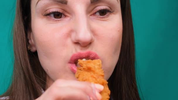 Jovem mulher feliz comendo frango frito, close-up. Mulher come asas de frango, ingestão de calorias e riscos para a saúde, colesterol — Vídeo de Stock