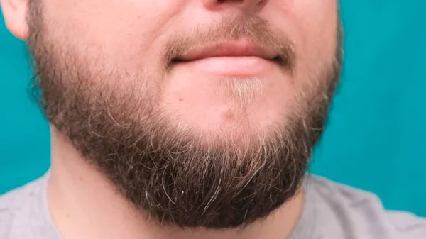 Detailní záběr mužských rtů a vousaté brady na zeleném pozadí — Stock fotografie