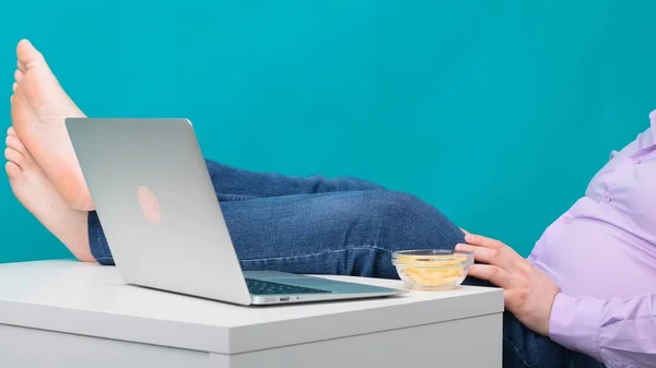 Primo piano di gambe maschili su un desktop vicino a un computer portatile. Il concetto di noia e stanchezza sul lavoro . — Foto Stock