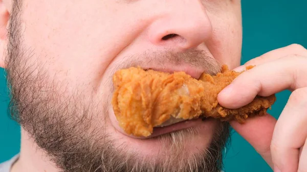 Close up de mordidas masculinas coxa de frango. O conceito de desnutrição, dieta, takeaway . — Fotografia de Stock