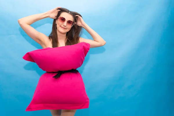 Красивая девушка в розовом платье из подушек на голубом фоне. Сумасшедший карантин. Мода 2020. Положи подушку. Вызов 2020 из-за изоляции дома . — стоковое фото