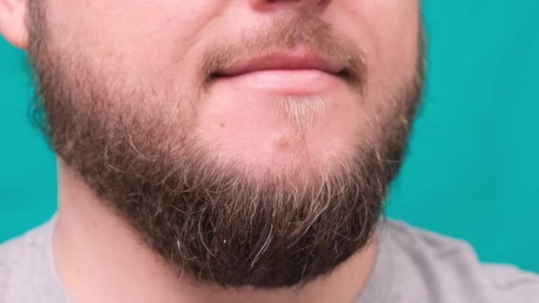 Közelkép a férfi ajkak és szakállas áll zöld háttér — Stock videók