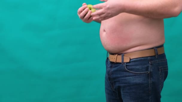 Hombre gordo con un vientre grande sostiene una manzana verde en su mano. El concepto de alimentación saludable y pérdida de peso, dieta . — Vídeo de stock