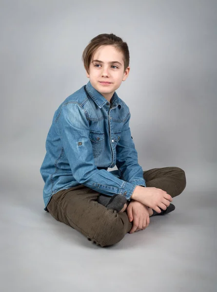 Мальчик-подросток сидит на полу — стоковое фото