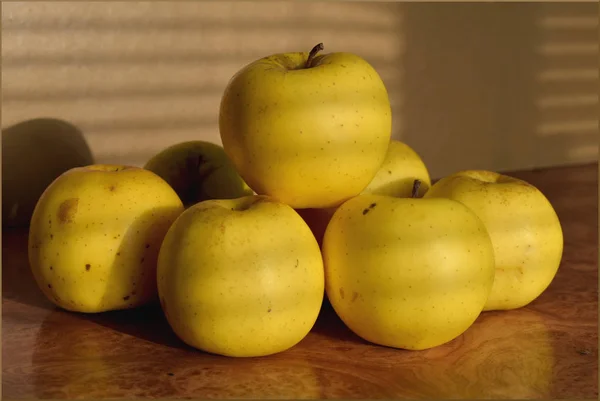 Ένα μπολ με φρούτα που κάθονται πάνω από ένα ξύλινο τραπέζι — Φωτογραφία Αρχείου