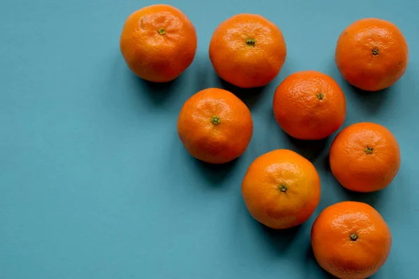 Mandarinler renkli bir yüzeyde yatarlar.. — Stok fotoğraf