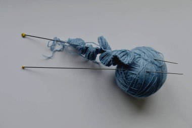 Örgü iğneleri ve yün iplik yumağı.