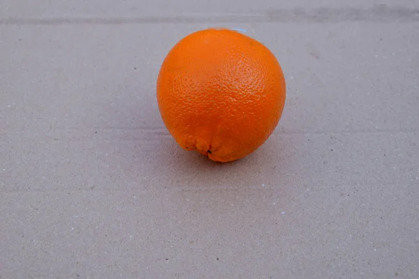 Laranja em papelão cinza . — Fotografia de Stock