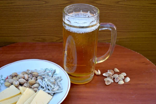 Um copo cheio de cerveja com anchovas . — Fotografia de Stock