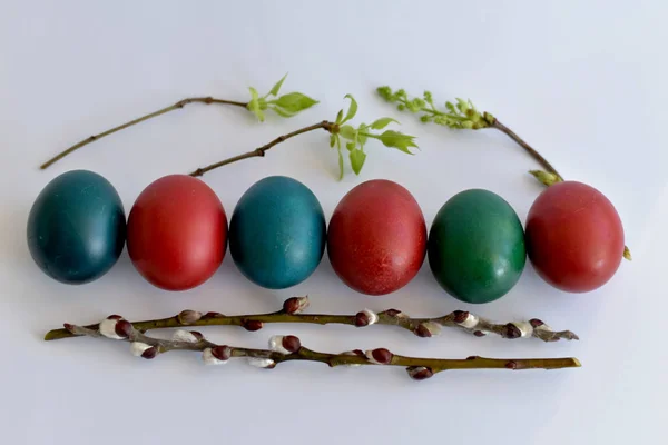 Oeufs de Pâques empilés en rangée et brindilles de saule sur la table . — Photo