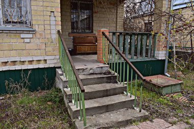 Evin verandasına çıkan bir merdiven üzüm bağıyla sarılmış..