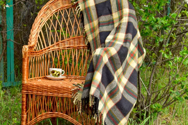 Una silla de mimbre hecha de ramitas fue instalada en el jardín bajo cerezas florecientes . — Foto de Stock