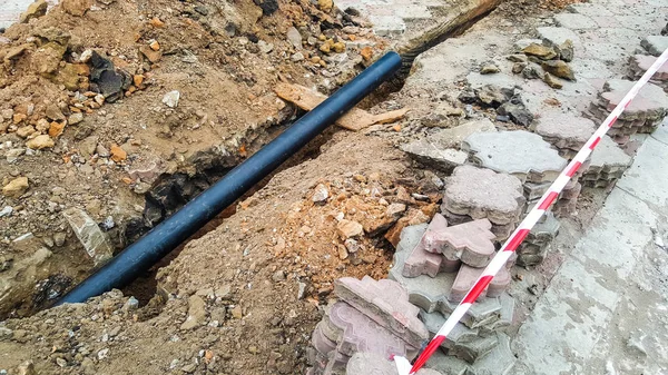 Laying installation of a new cable in a plastic pipe. Digging dr
