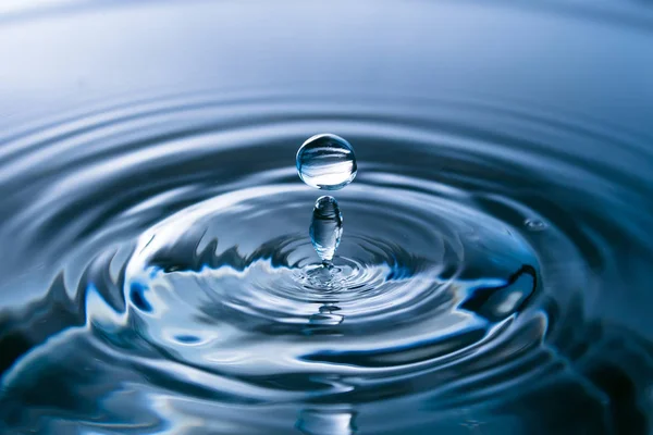Een plons water van dichtbij. Waterdruppel. Een blauwe druppel water. Vallen. — Stockfoto