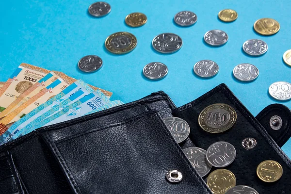 Tenge op blauwe achtergrond met munten. Tenge is de nationale curre — Stockfoto