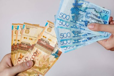 Kağıt banknotlar. Kzt insanları beyaz bada ellerinde tutuyor.
