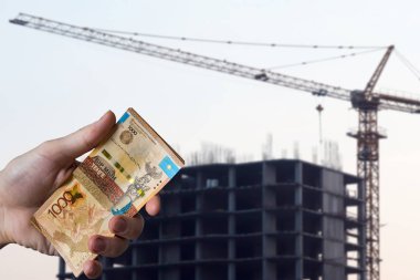 Elleri para tenjanı tutuyordu. Evin arka planında C altındaydı.