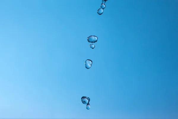 Falling water drops on a blue background. — 스톡 사진