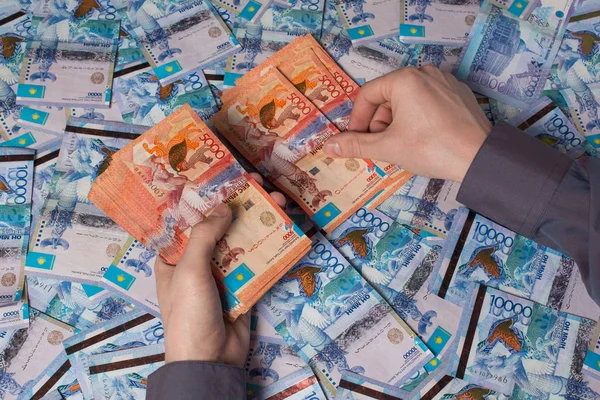 Las manos cuentan Kazajstán tenge dinero. Billetes de papel tenge KZT. T — Foto de Stock