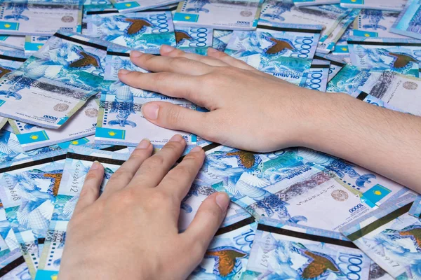 Las manos están sobre una mesa llena de dinero de Kazajstán. Papel bankn — Foto de Stock