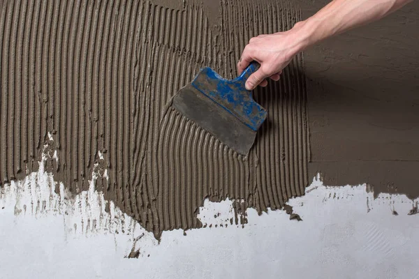 Duvarı onar. Duvara sıva yapıyorum. Spatulayı tutarken de...