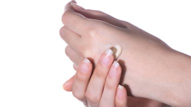 Cilt ve cilt bakımı ve dermatolojisi. Kız beyaz arka planda elin cildine nemlendirici ya da losyon sürüyor. Kaplıca, evde ya da güzellik salonunda cilt bakımı.