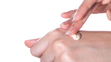 Kız, elin cildine nemlendirici ya da losyonu yakın plan izole edilmiş beyaz bir arka plan üzerine sürer.Kaplıca, evde ya da güzellik salonunda cilt bakımı. Cilt ve kozmetolojide tedavi ve su kaybı
