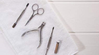 Manikür veya pedikür seti aletleri güzellik salonundaki beyaz havluyla masaya yerleştirilir. Güzellik salonu ya da güzellik salonu ekipmanları. Manikür ve manikür ve manikür için..